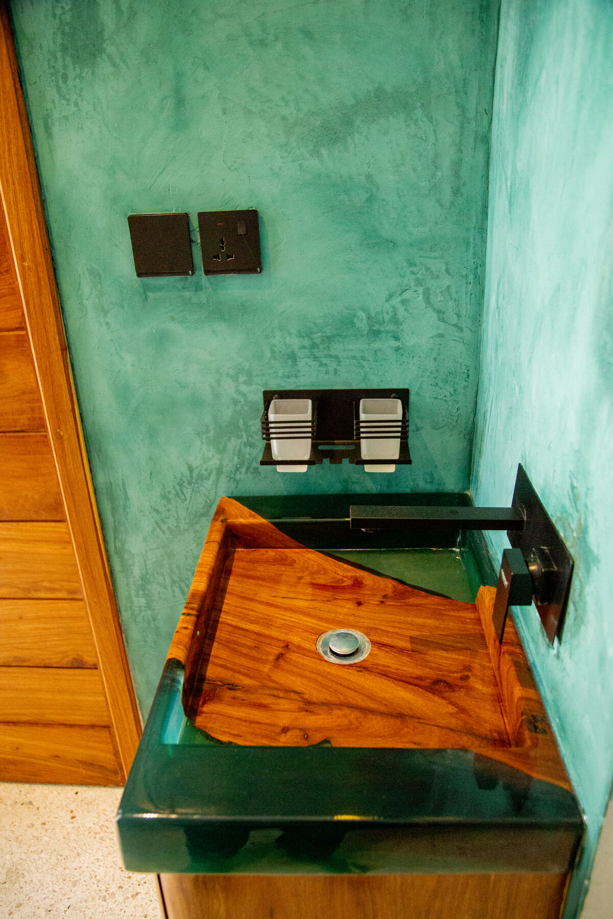 Carved wooden basin on green polished cement