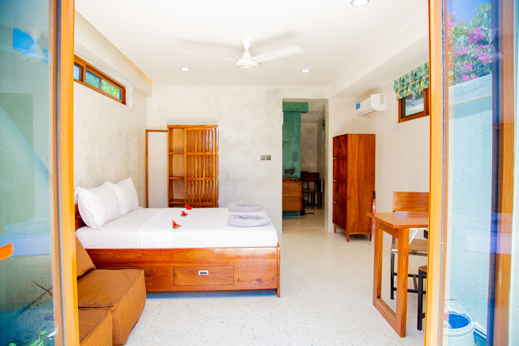 Bedroom with hand-made wooden bed and sea-glass window