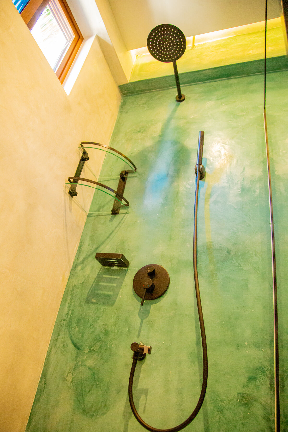 Sea-green polished cement shower with rainfall head
